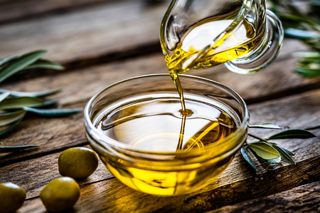 vertiendo aceite de oliva virgen extra en un recipiente 